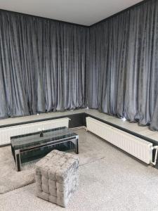 a room with curtains and a table and a couch at Glow Sahara in Văleni