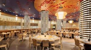 珠海市にあるChimelong Hengqin Bay Hotelのテーブルと椅子とシャンデリアのあるダイニングルーム