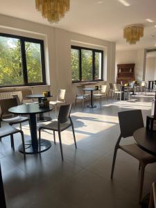 a waiting room with tables and chairs and windows at Albergo Casa dell'Ospite in Brescia