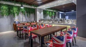 a restaurant with chairs and a table and a kitchen at James Joyce Coffetel Shenyang North Railway Station Qishan Road Metro Station in Shenyang