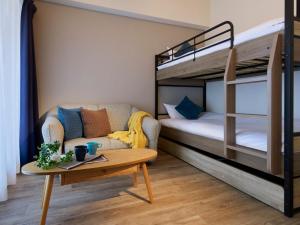 a living room with a bunk bed and a coffee table at Minn Umeda East in Osaka