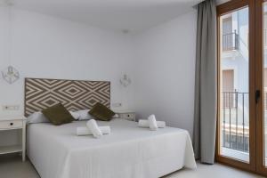 a white bedroom with a large white bed and a window at El Jazmín del Patio in Nerja +64 photos