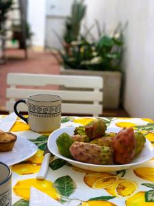 ein Tisch mit einem Teller Essen und einer Tasse Kaffee in der Unterkunft Il Fico d'India - Home Salento com in Ugento