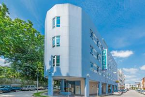 - un bâtiment bleu et blanc dans une rue de la ville dans l'établissement Hotel 81 Osaka, à Singapour