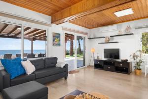 een woonkamer met een bank en een televisie bij Shoreline Beach House in Larnaka