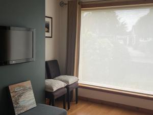 - un salon avec une grande fenêtre et 2 chaises dans l'établissement Balnakyle, à Inverness