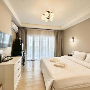 a hotel room with a large bed and a television at J STAR in Jomtien Beach