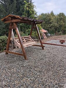 a wooden picnic table sitting on a pile of gravel at Casuta D&M in Cisnădie