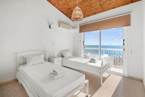 twee bedden in een slaapkamer met uitzicht op de oceaan bij Shoreline Beach House in Larnaka