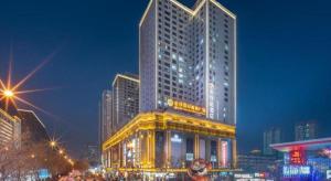a large tall building with lights in a city at night at 7 Days Premium Xi'an Dayan Tower Xiaozhai Metro Station in Xi'an