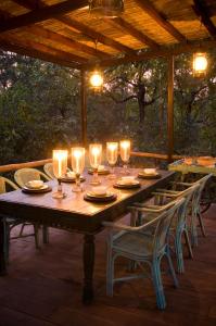 un patio con tavolo in legno con luci e sedie. di Baghvan Pench National Park - A Taj Safari Lodge a Behrai