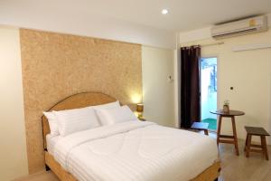 Un dormitorio con una gran cama blanca y una mesa en Area 69 (Don Muang Airport), en Bangkok