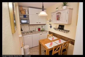 a small kitchen with white cabinets and a table at Allgäuer Bergerlebnis mit Hallenbad in Fischen +35 photos