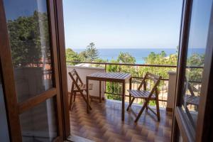 a balcony with a table and chairs and the ocean at Villa Acquamarina per Gruppi e Famiglie a Capo Vaticano Costa degli Dei in Santa Maria