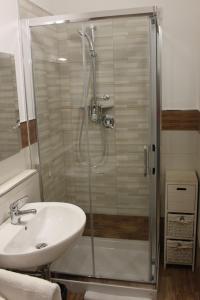 een badkamer met een wastafel en een douche met een glazen deur bij Mille Charme and Relais in Sassari