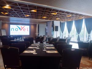 a conference room with tables and chairs and a screen at Novel Hotel Manila in Manila +45 photos