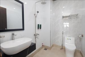 Un baño blanco con lavabo e inodoro. en Bình Triệu Hotel - Gò Vấp, en Ho Chi Minh