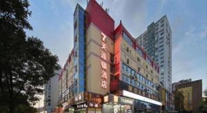 a tall building with a sign on the side of it at 7 Days Inn West Gate of Taiyuan University of Technology in Taiyuan