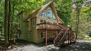 una casa con una gran ventana y una escalera de madera en Tawny and Peaceful Game Room Firepit PatioDeck Workspace, en Arrowhead Lake