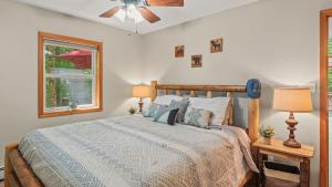 a bedroom with a bed and a ceiling fan at Lake Pool Access Game Room Firepit Deck Tawny and Peaceful by AvantStay in Arrowhead Lake