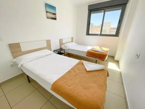 a small room with two beds and a window at Apartamentos Benicarló Lowcost 3000 in Benicarló