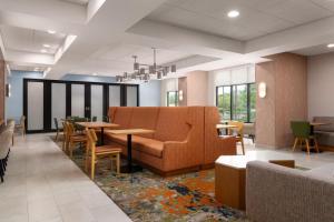 a waiting room with a couch and tables at Hampton Inn Neptune in Neptune City