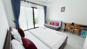 a bedroom with a bed and a couch and a window at O Mary River Resort in Sihanoukville