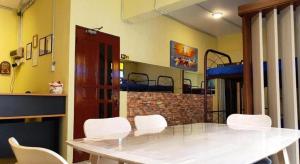 a dining room with a white table and white chairs at Hotel O Arriva Travellers in Kuching