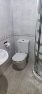 a white bathroom with a toilet and a sink at Habitación en piso compartido in Terrassa