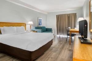 une chambre d'hôtel avec un grand lit et une télévision dans l'établissement Rodeway Inn, à Saint-Jean 23 autres photos