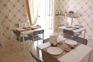 a dining room with two tables and chairs and a window at Terra Lucana B&B in Matera