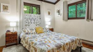 a bedroom with a bed and two windows at The Four Seasonal by AvantStay Hot Tub Spacious Deck Fire Pit in Pocono Pines