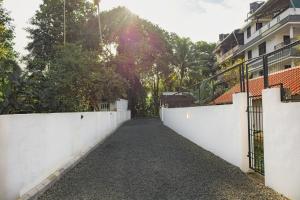 a street in a city with a white fence at Greens Residency in Tripunnittara
