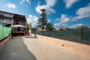 una pista de tenis con una valla y un árbol en Villa Marzla, en Cassano delle Murge
