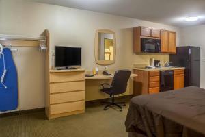 a hotel room with a bed and a desk with a computer at Suburban Studios Triadelphia - Wheeling at The Highlands in Triadelphia