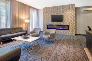 a living room with a couch and chairs and a tv at Quality Inn Centre-Ville in Montréal