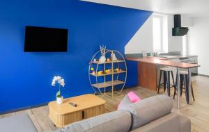 a living room with a couch and a blue wall at Béthune Maison au TOP plein pied calme et rénové, capacité 4 personnes in Béthune