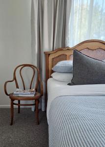 1 dormitorio con 1 cama y 1 silla junto a una ventana en Harrington Holiday House, en Harrington