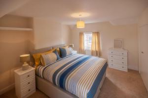 a bedroom with a bed and a dresser and a window at Luxury Town Centre Apartment in Stratford-upon-Avon