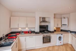 a kitchen with white cabinets and a washer and dryer at Town Centre Apartment Perfect Location with on-street parking in Stratford-upon-Avon