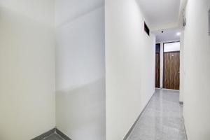 a hallway with white walls and a door at Hotel O Happy Stay in New Delhi