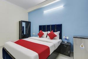 a bedroom with a large bed with red pillows at Hotel O Happy Stay in New Delhi +18 photos