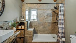 a bathroom with a large tub and a shower at The Bigwood Cabin by AvantStay Hot Tub Firepit Pool Table Private Yard in Long Pond +73 photos