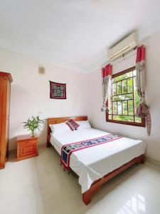 een slaapkamer met twee bedden en een raam bij Mai Ha Backpackers Hostel & Garden Lounge in Mai Chau