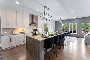 une cuisine avec un grand îlot avec des chaises de bar noires dans l'établissement Elysian Shores w/Heated Pool & Optional Boat Rental, à Mooresville