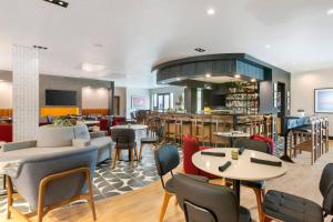 a restaurant with tables and chairs and a bar at Cambria Hotel Spokane Airport in Spokane