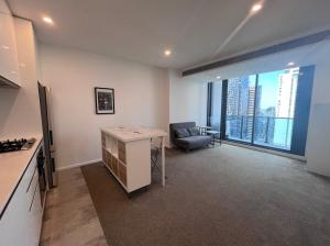 a kitchen and living room with a couch and a table at Where Style Meets Convenience in Melbourne CBD in Melbourne