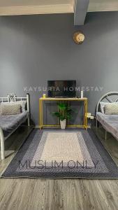 a room with two beds and a rug on the floor at KAY'SURIA HOMESTAY in Rawang