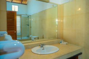 Un baño con lavabo y un espejo grande. en Villa Inavni, en Talawatugoda