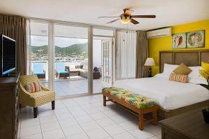 a bedroom with a bed and a television and a balcony at The Atrium Beach Resort and Spa Sint Maarten, Ascend Hotel Collection in Simpson Bay